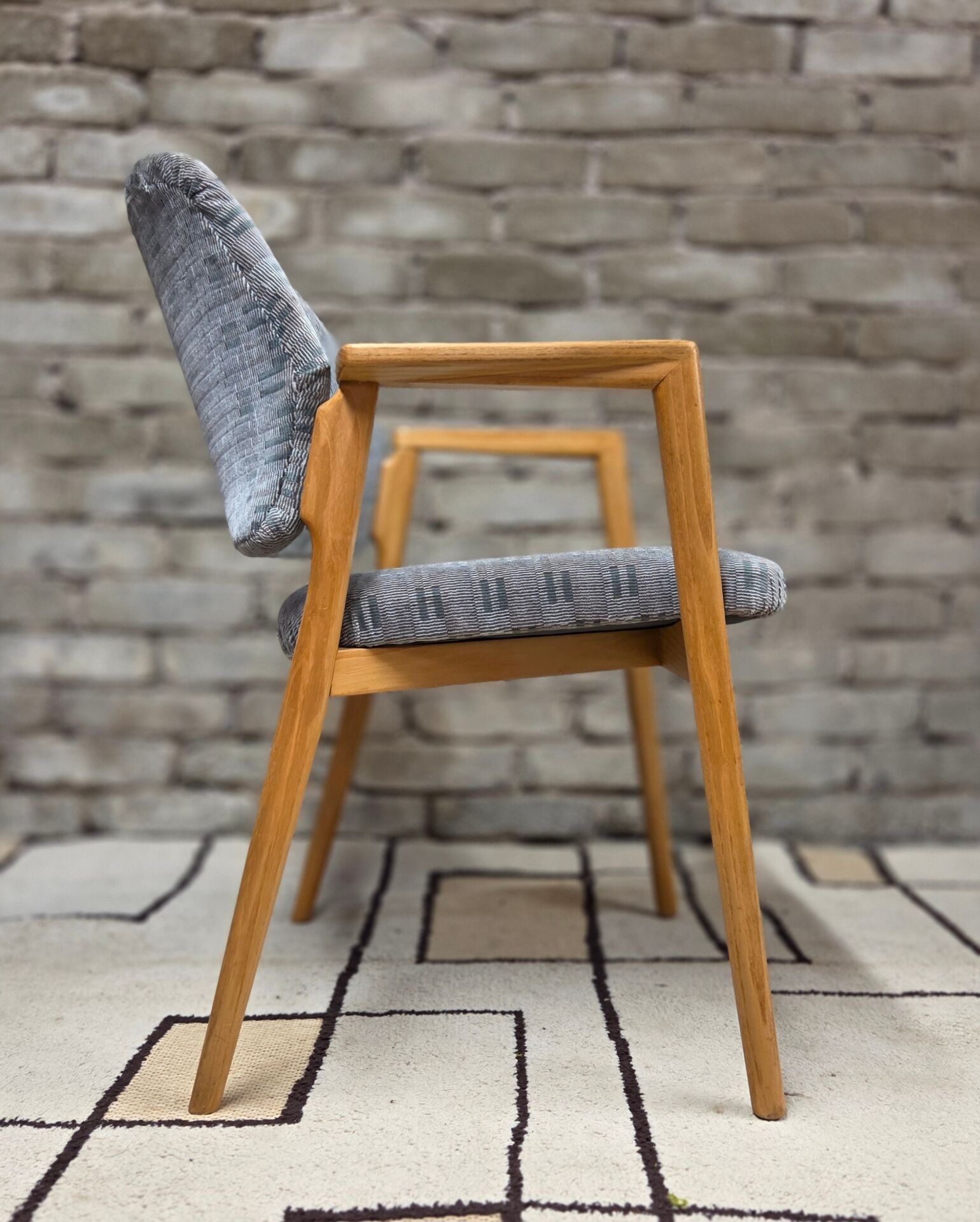 Vintage armchair from the 60s/70s in wood and grey fabric – with armrests.