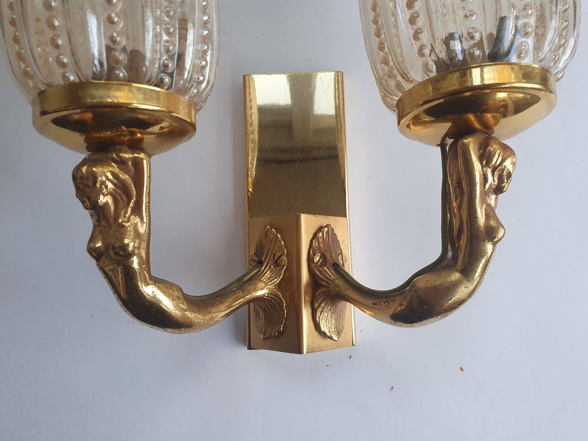 Golden bronze wall lamp with mermaids for an old bathroom.
