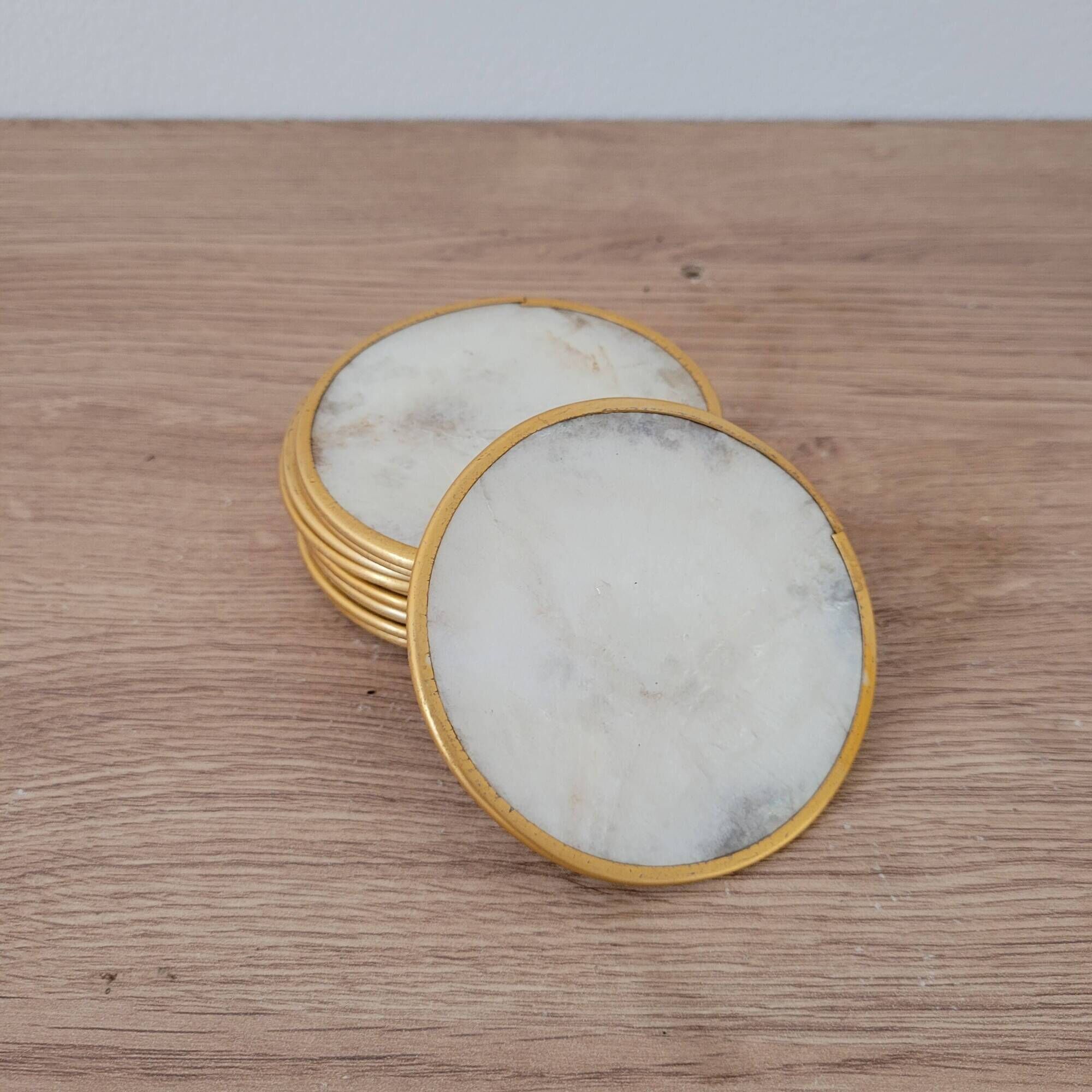 Set of 11 mother-of-pearl coasters with brass rim.