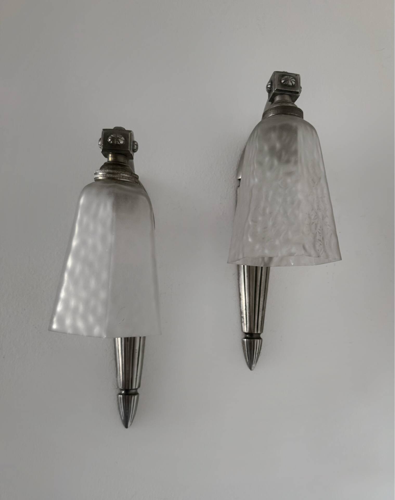 Silver Art Deco wall lights with frosted glass.
