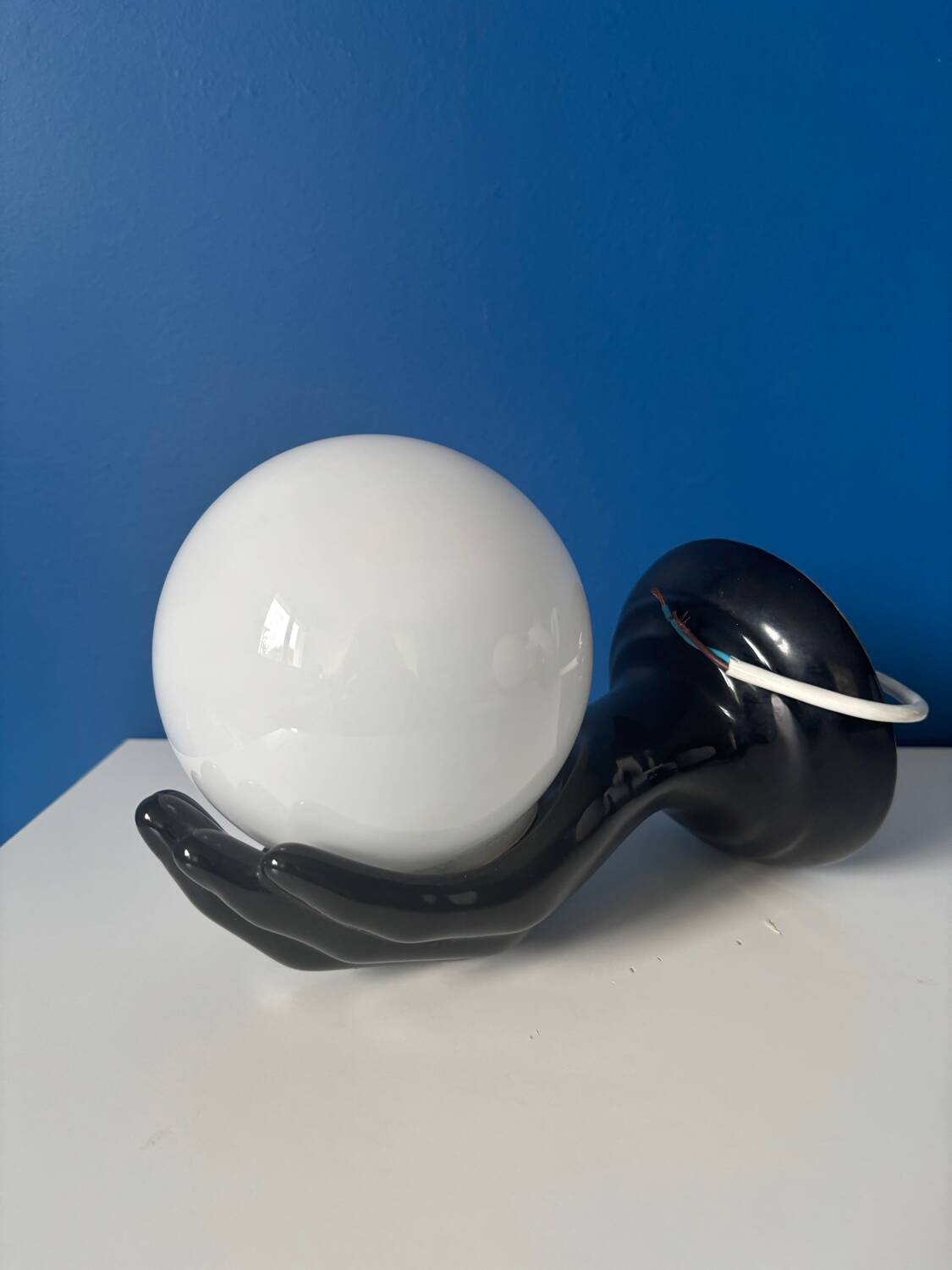 Vintage wall sconce with black hand and white opaline glass globe, 1970s L