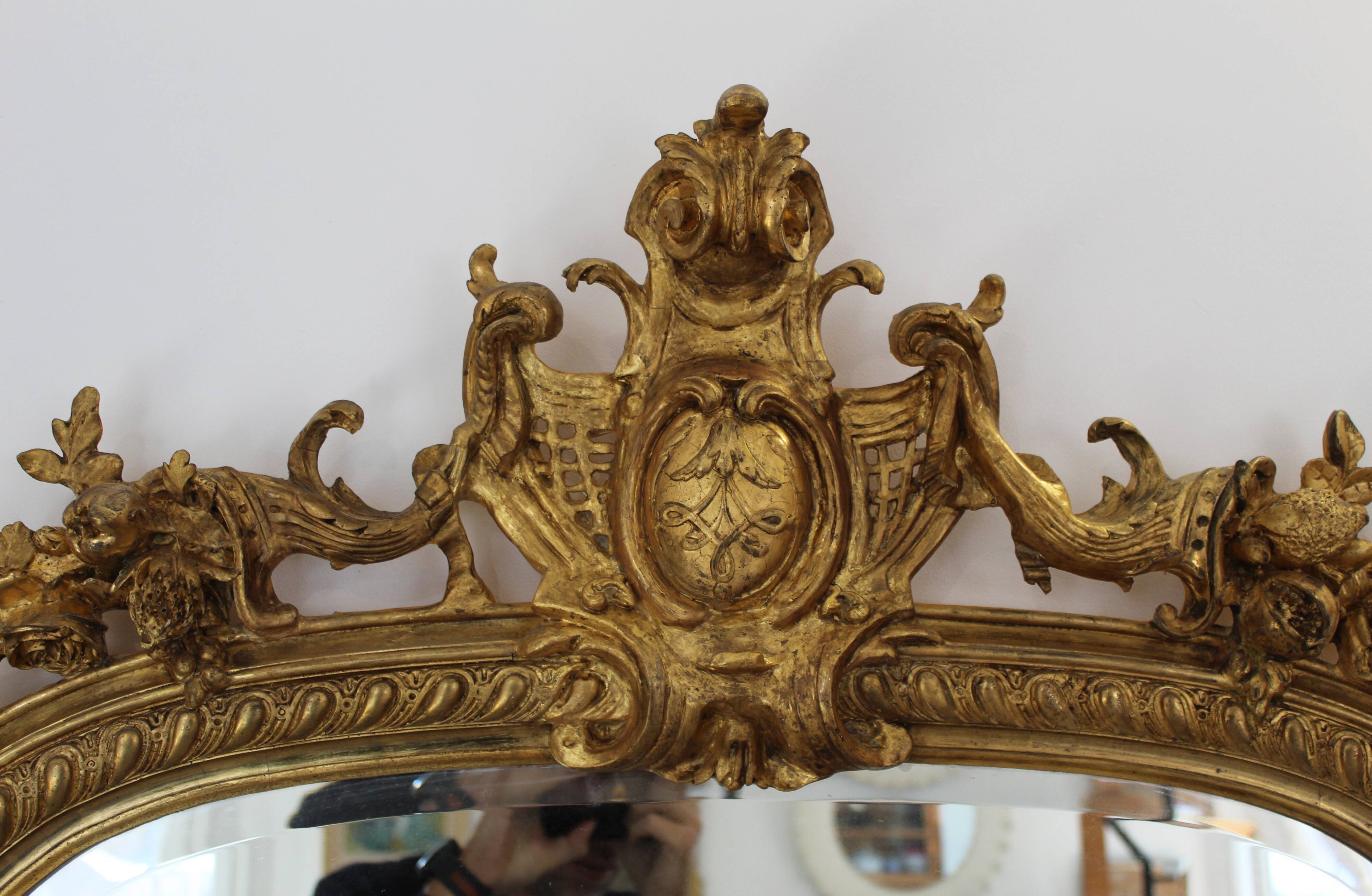 Large 19th-century wooden and gilt-studded mirror decorated with a cornucopia motif.