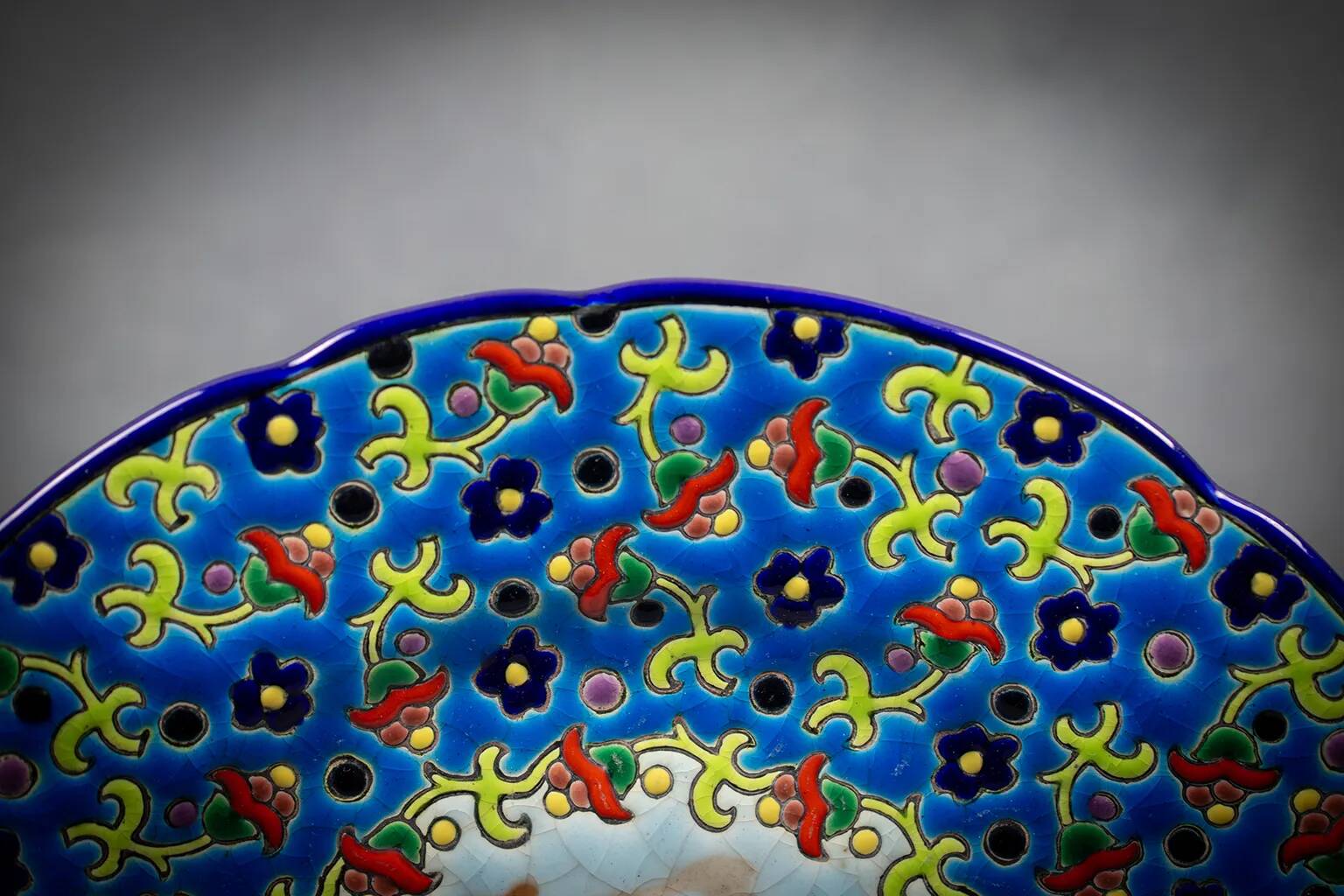 Longwy plate with polychrome enamels, decorated with the "City of Iron" motif.