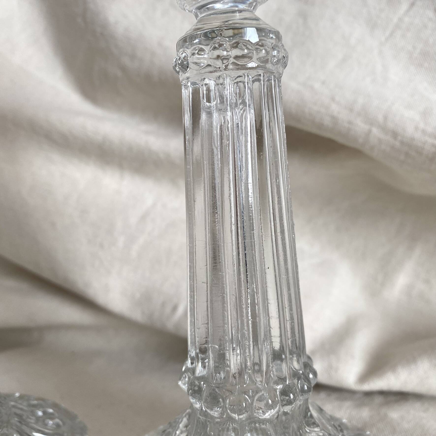 Column candle holders in moulded glass made in France.