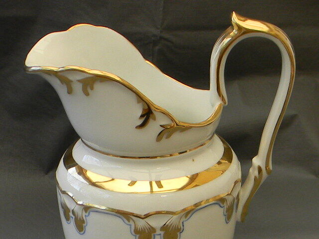 Milk jug or antique pitcher in white and gold porcelain.