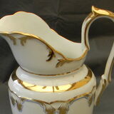 Milk jug or antique pitcher in white and gold porcelain.
