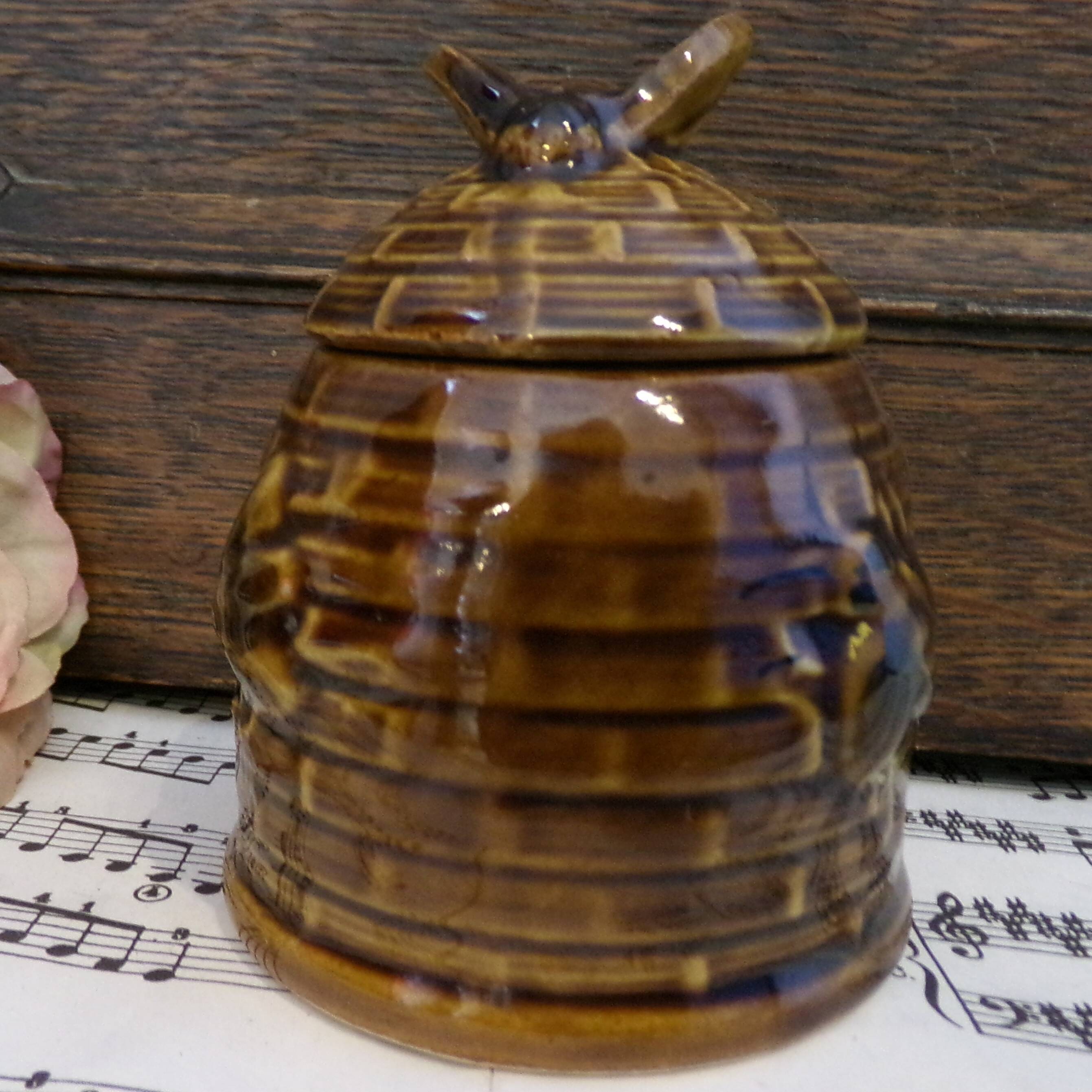 Honey pot in the shape of a hive decorated with bees.