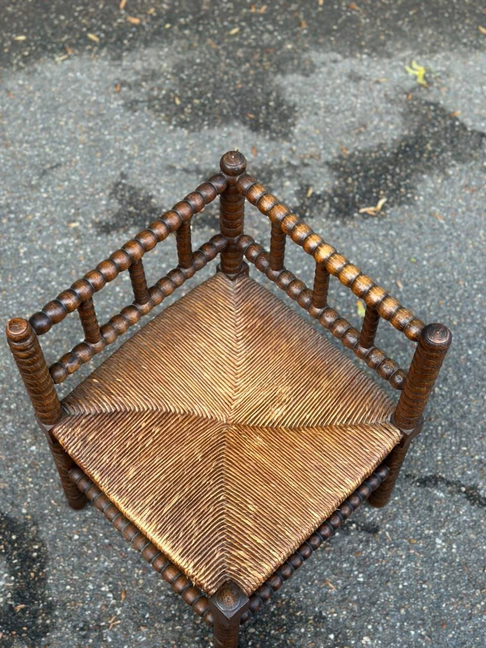 Brutalist corner chair in turned wood with straw bobbins, 1960.