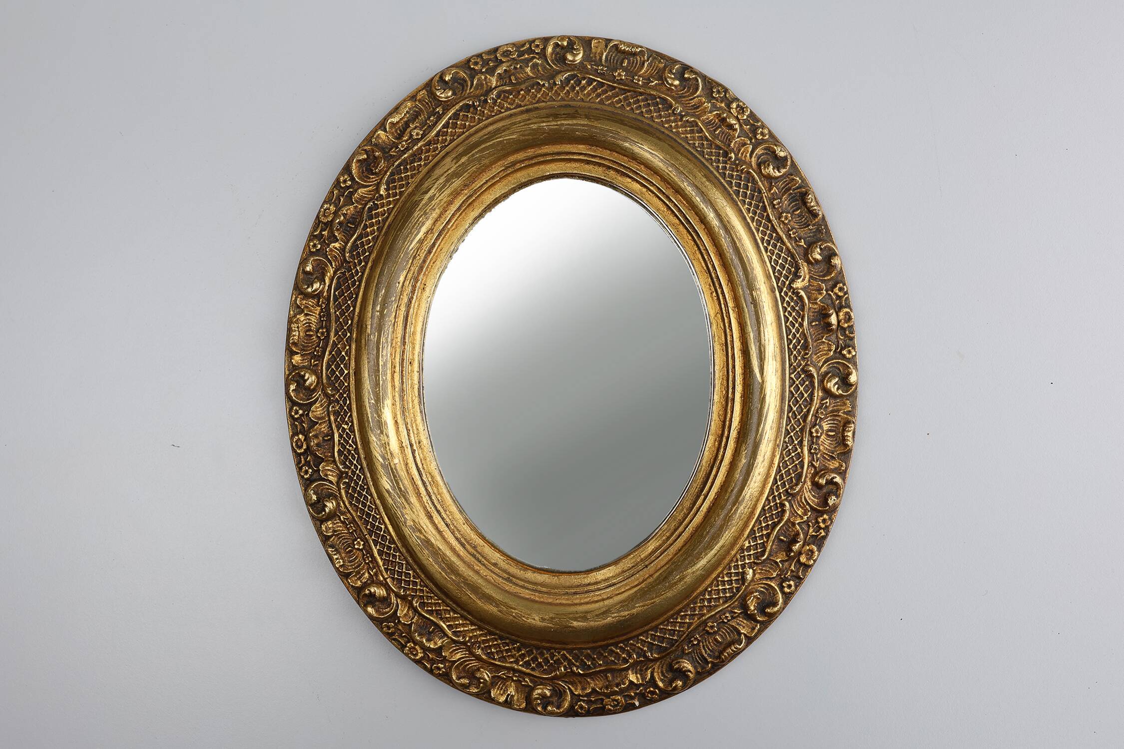 French Baroque style oval mirror in gilded wood with floral decorations