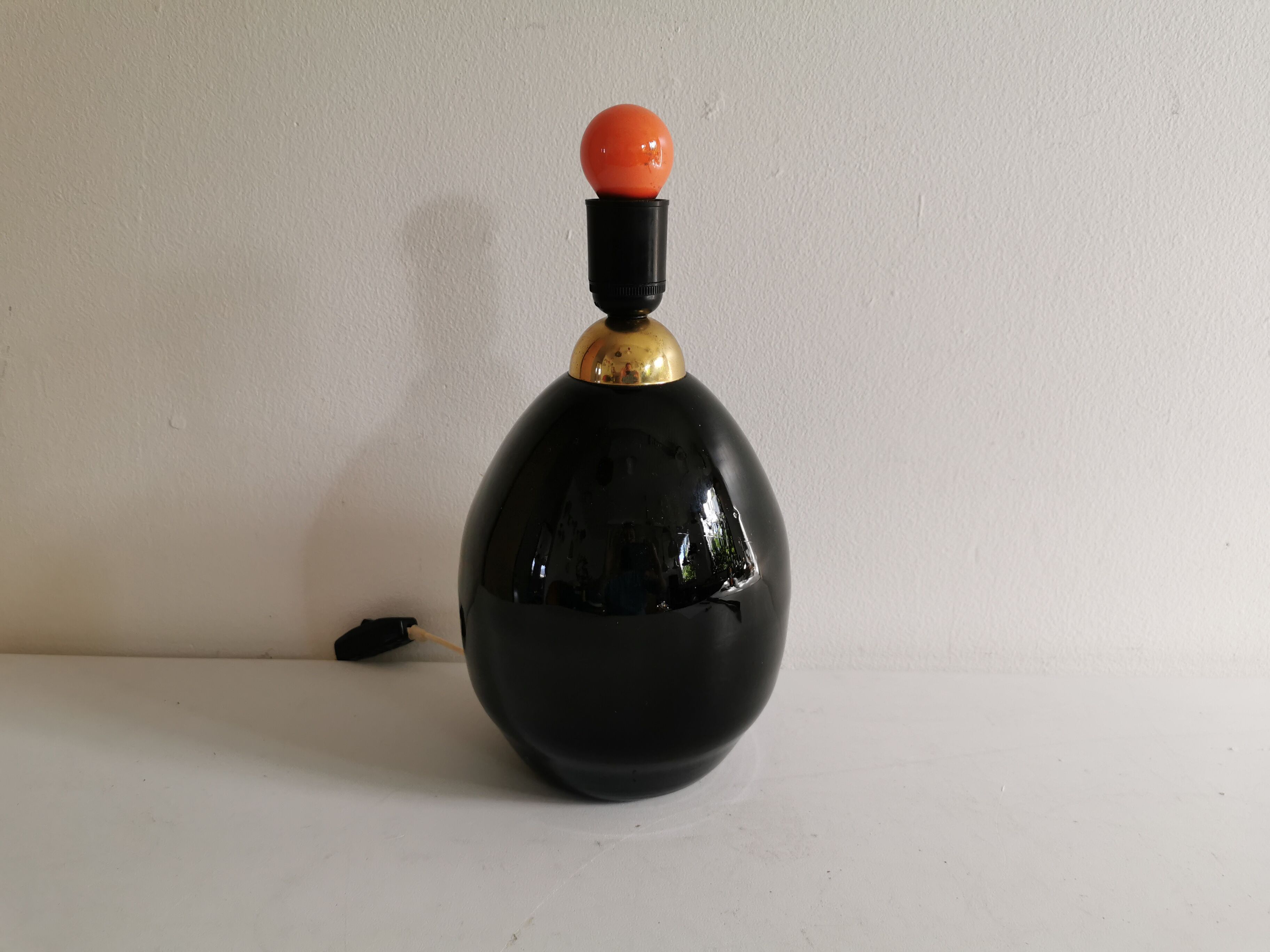 Table lamp, made of handmade coal-black glass, with brass coloured top.