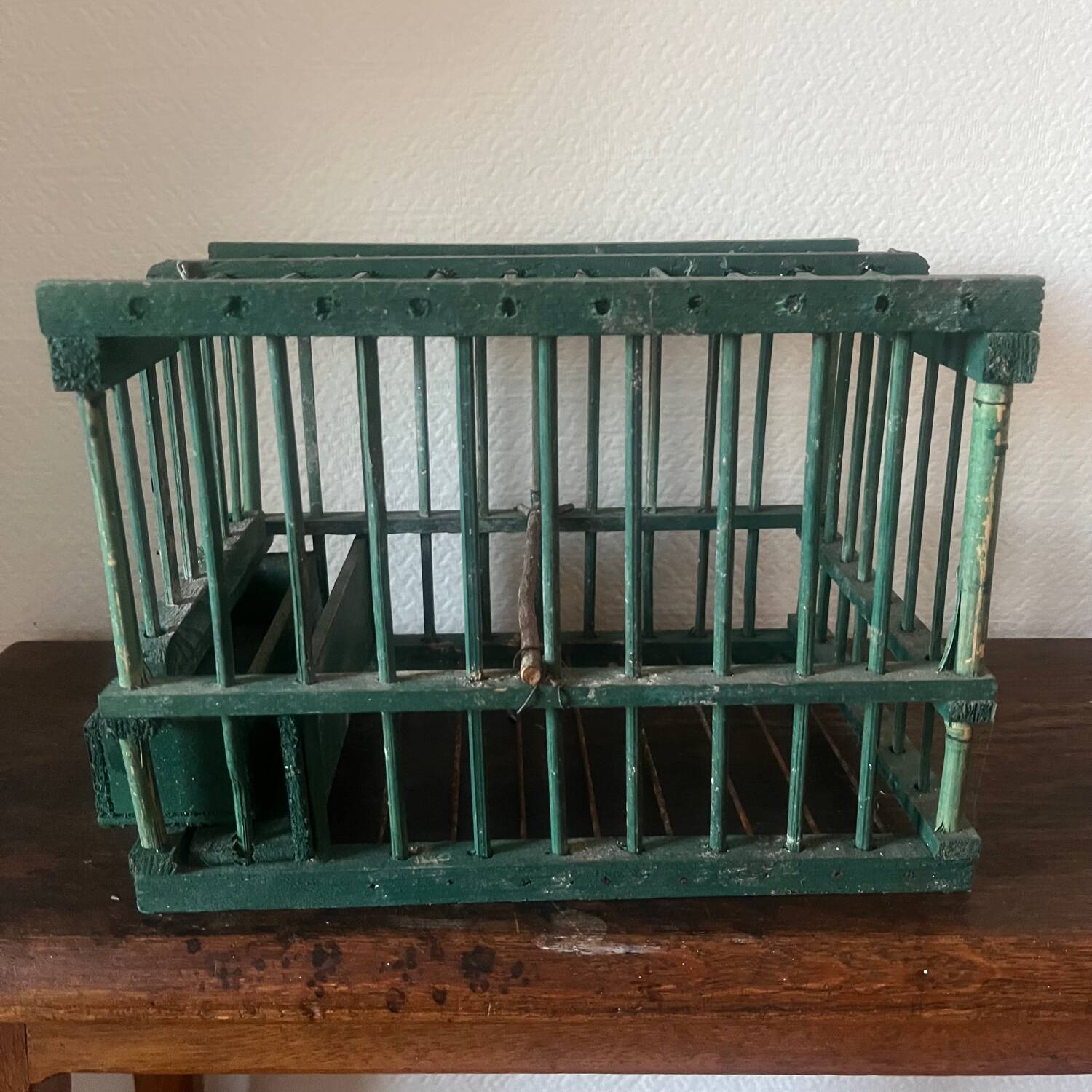 old bird cage made of wood and painted green