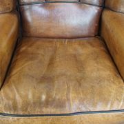 Cognac-colored sheep leather wingback chair finished with black piping