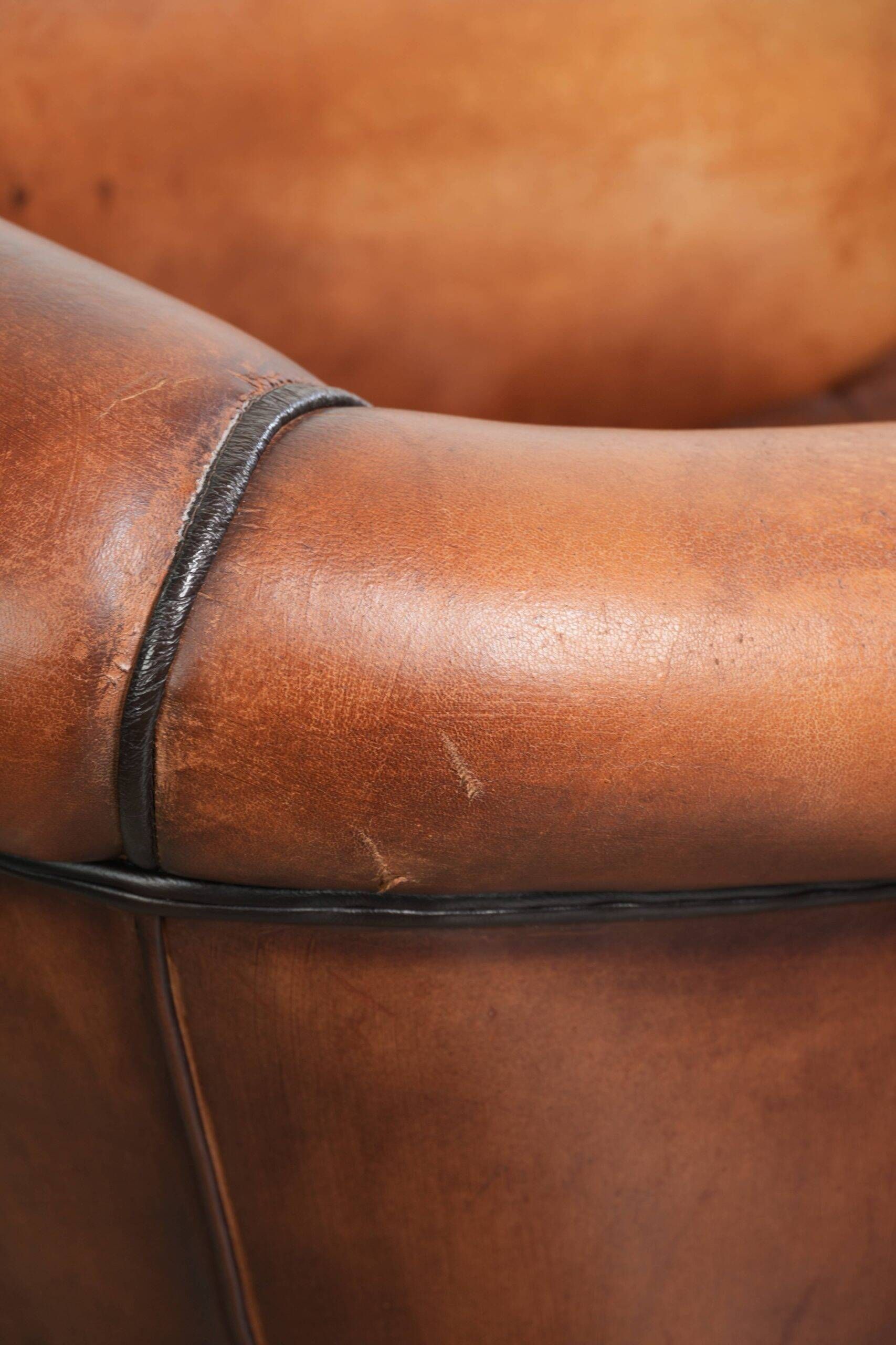 Vintage sheepskin club armchair finished with black piping