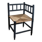Antique black turned wood corner chair with a straw seat.