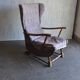 Vintage brown wooden rocking chair from the 1950s, wingback backrest and rocking base.