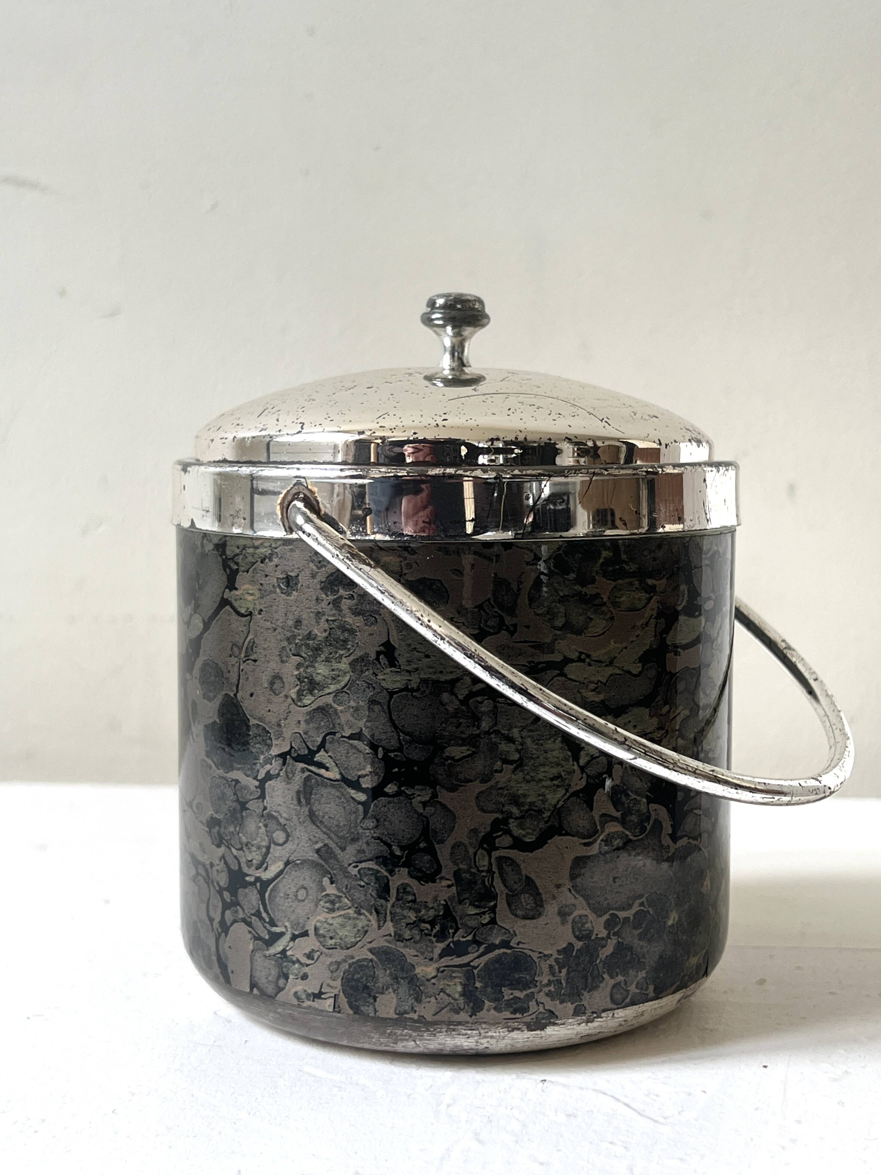 Vintage chrome metal ice bucket with black marbled design, 1970s style.