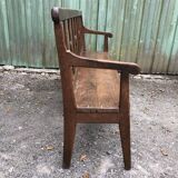 Duo of old solid oak benches with backs and armrests.