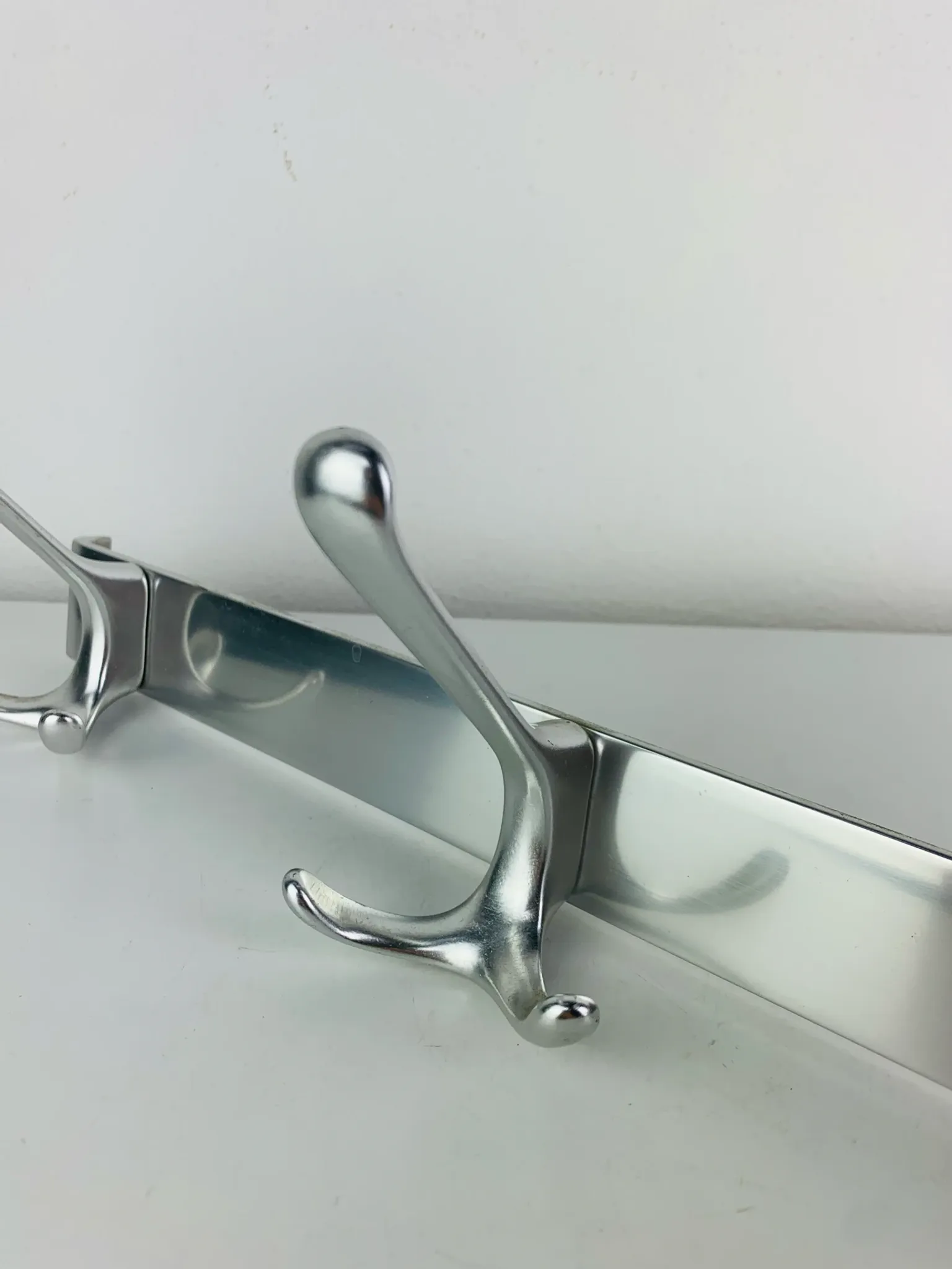 Wall-mounted coat rack, strip of 3 aluminium hooks from the 1960s.
