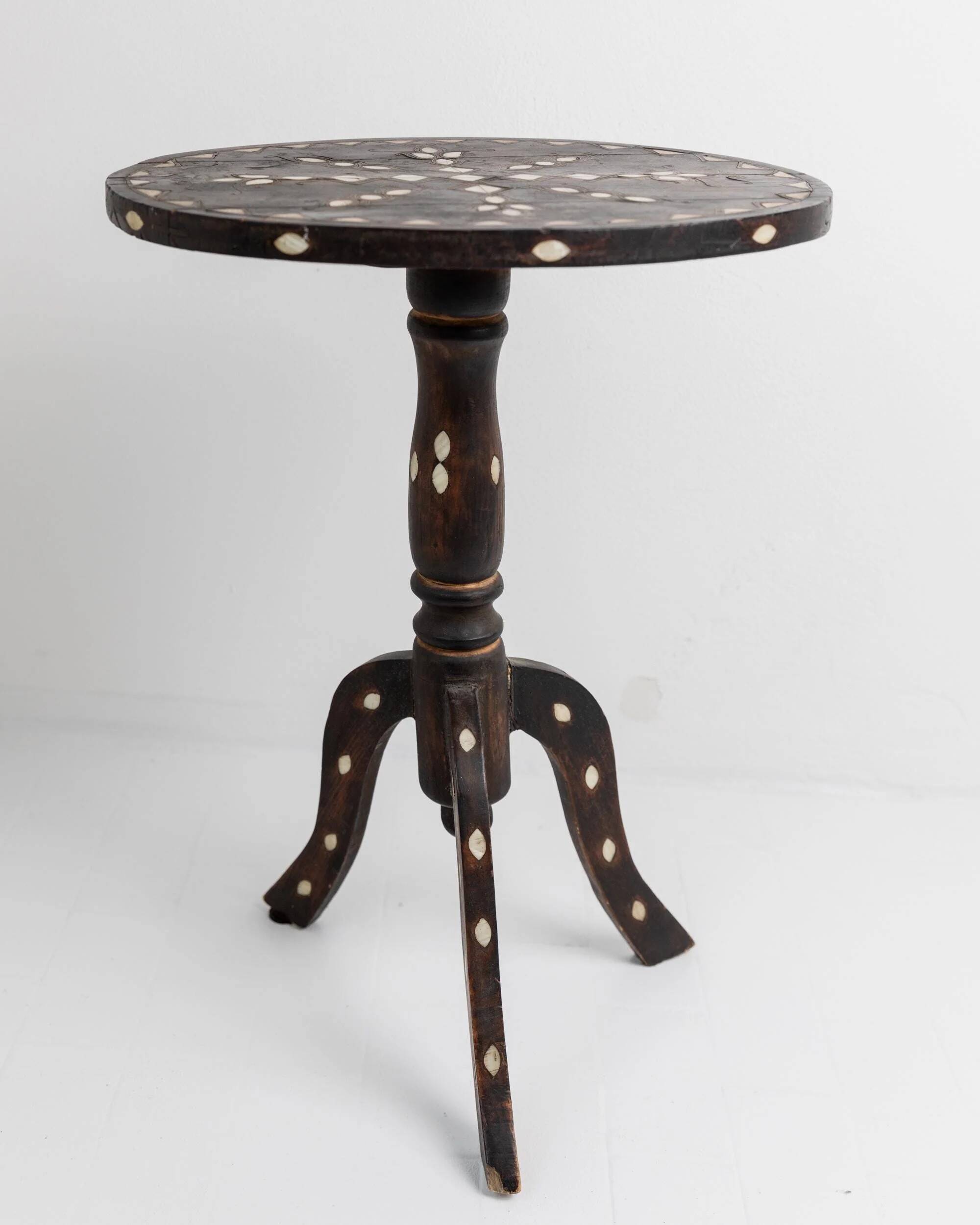 Vintage side table from the early 19th century, dark wood with mother-of-pearl inlays, oval shape with three legs, ethnic style.