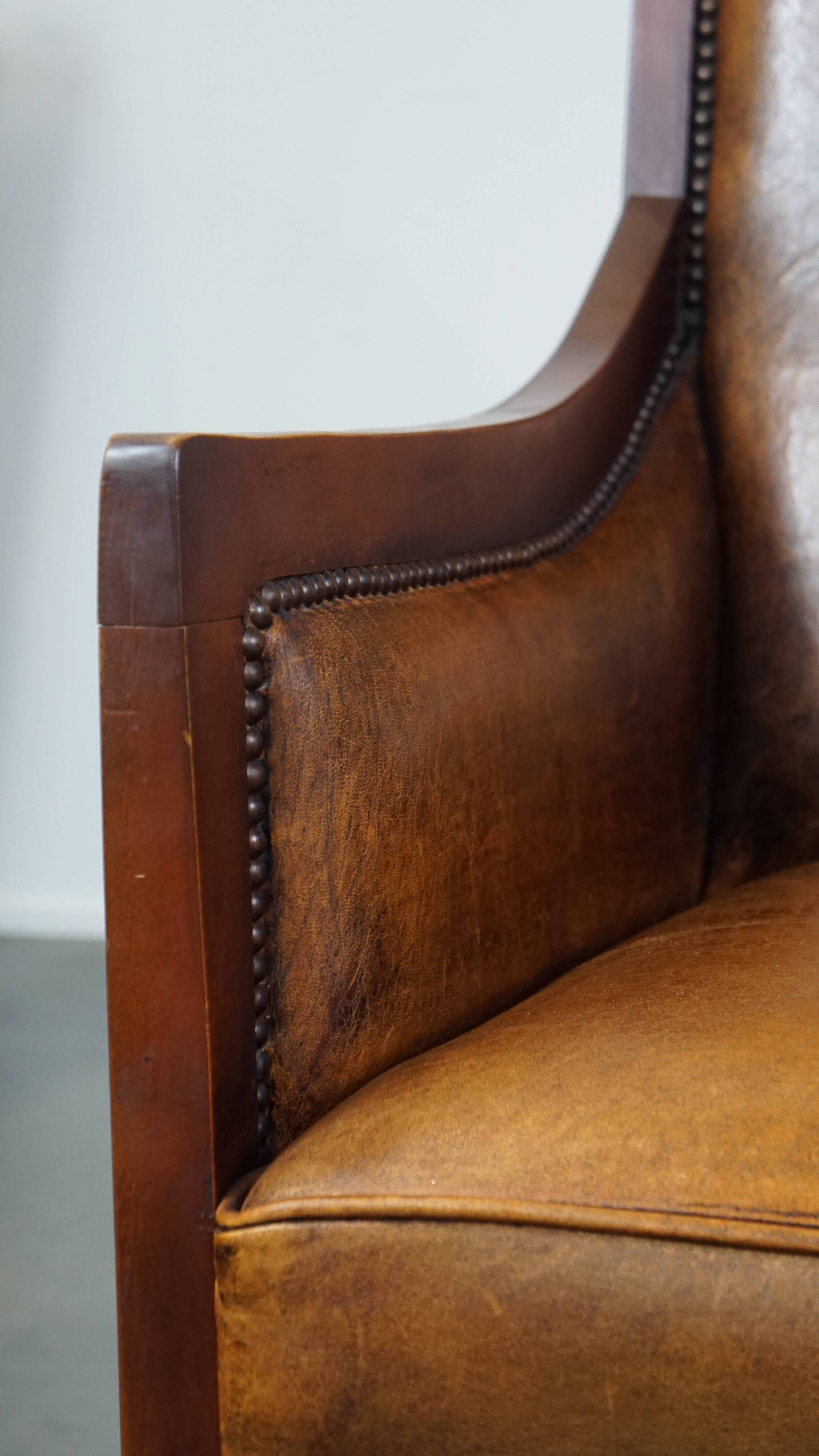 Sheepskin and wooden vintage Art Deco design armchair in a cognac color