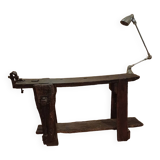 Small, very old, brutalist workbench equipped with a period workshop lamp