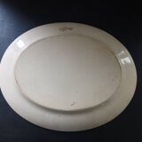 Large antique plate stamped with a fauna and flora pattern.