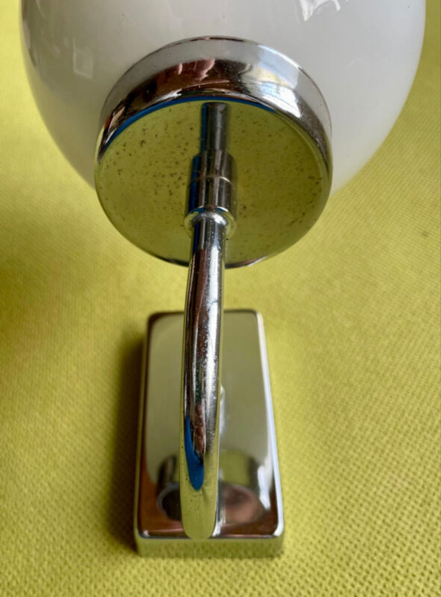 Pair of chrome metal wall lights with white glass globe.
