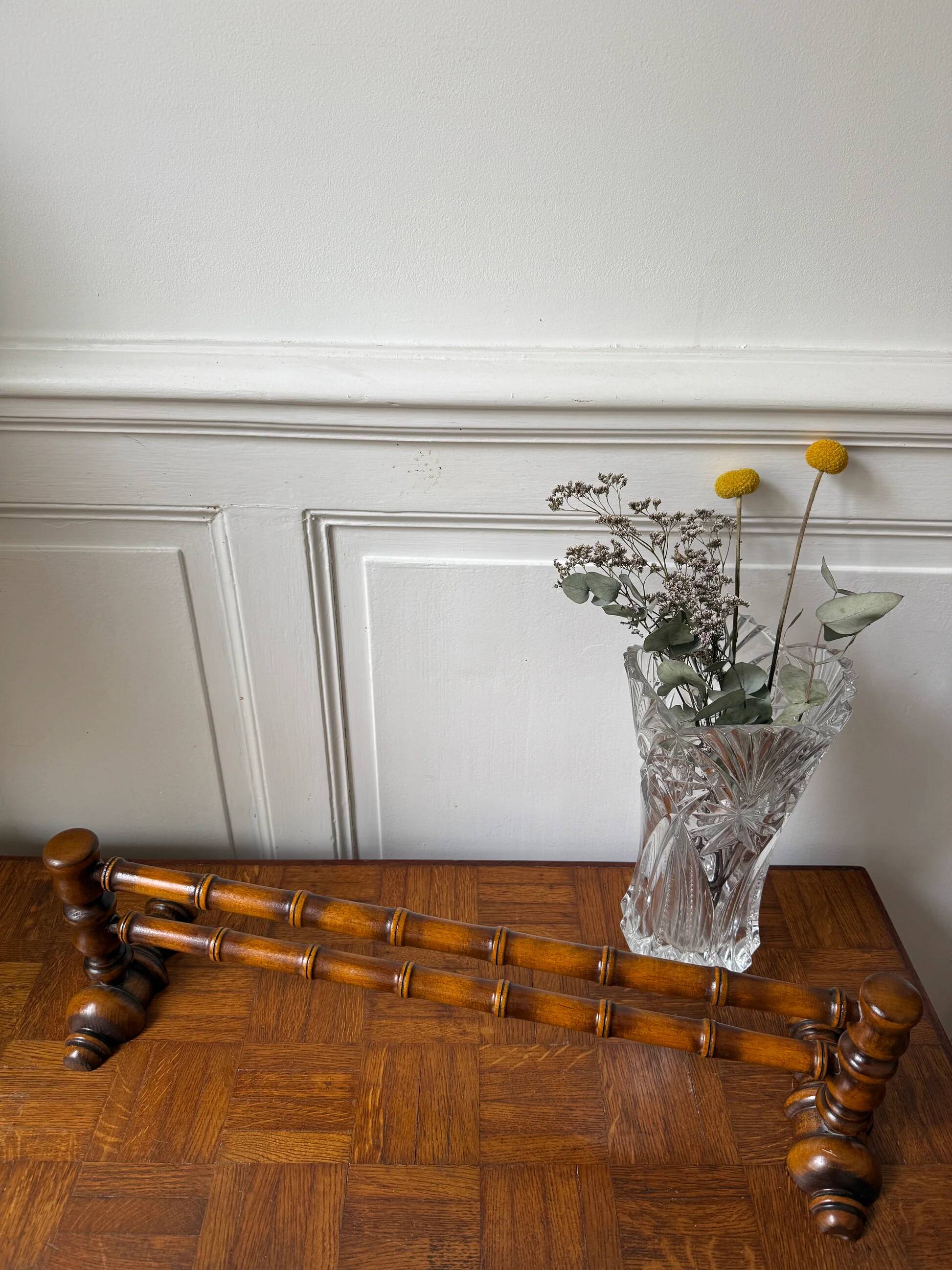 Wall-mounted coat rack made of turned wood in a bamboo style.
