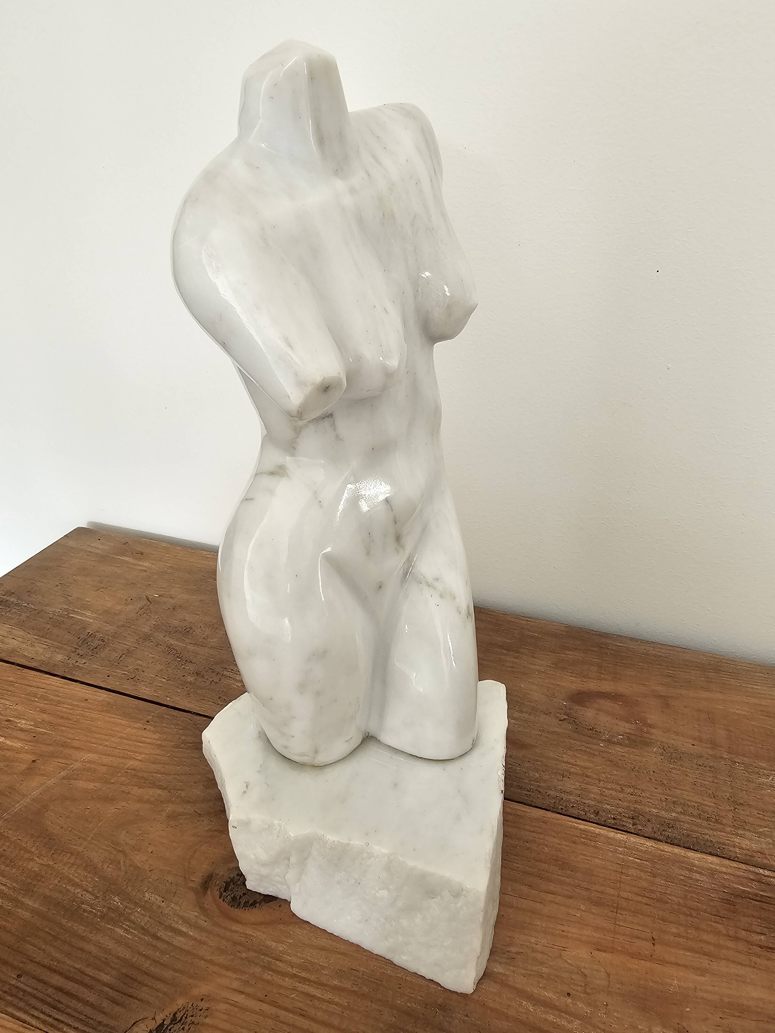 Sculpture of a female torso in white marble.