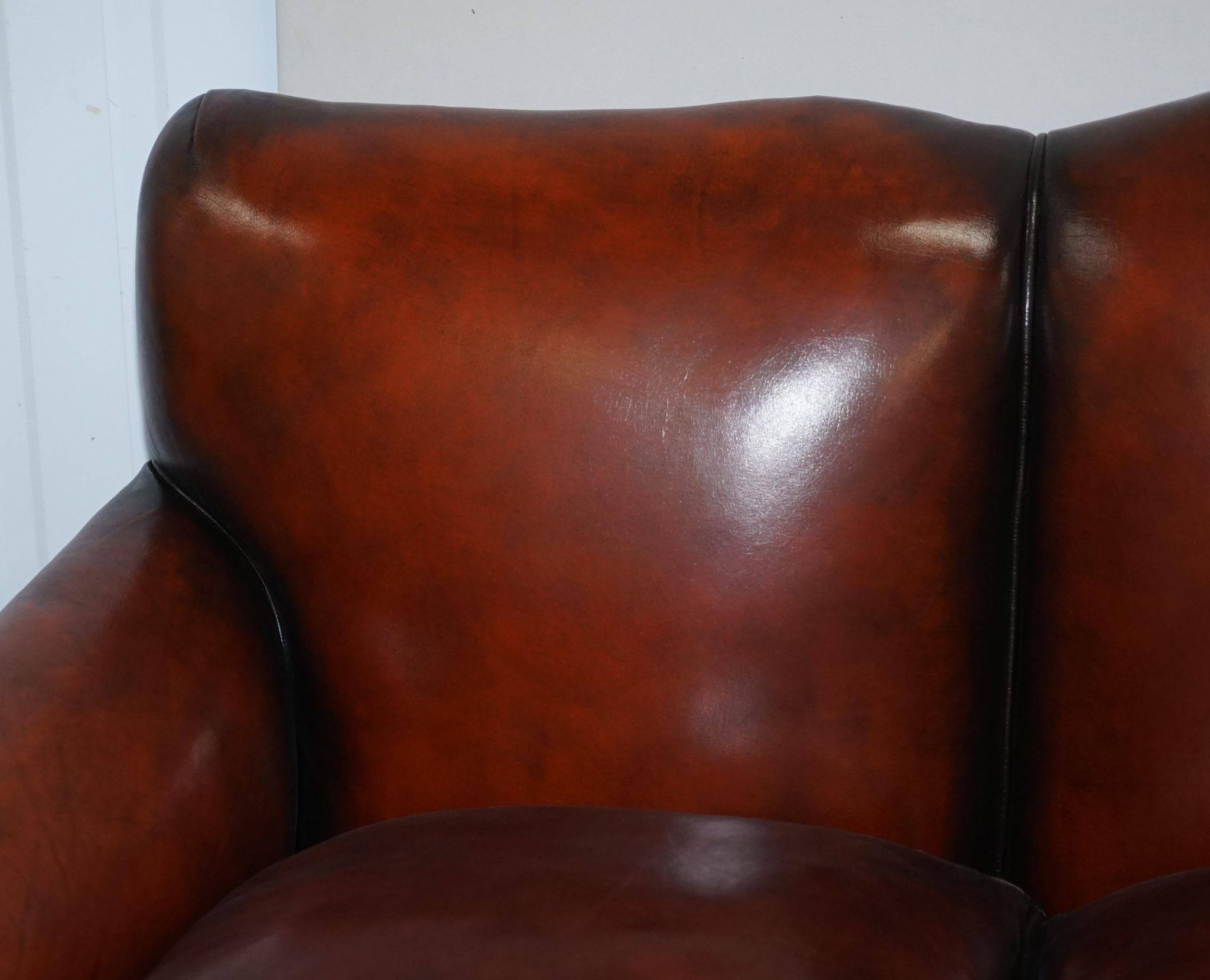 Restored Victorian sofa in leather with claw feet and feather cushions.