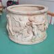 Round white stone pot cover with a farandole of angels
