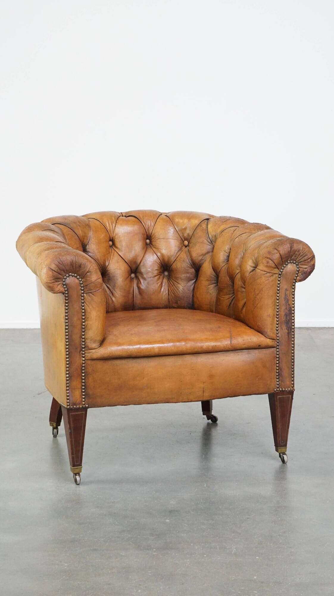 Antique, characteristic sheepskin chesterfield club chair on wheels