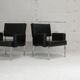 Paire de fauteuils piètement inox, simili-cuir noir, France, circa 1970