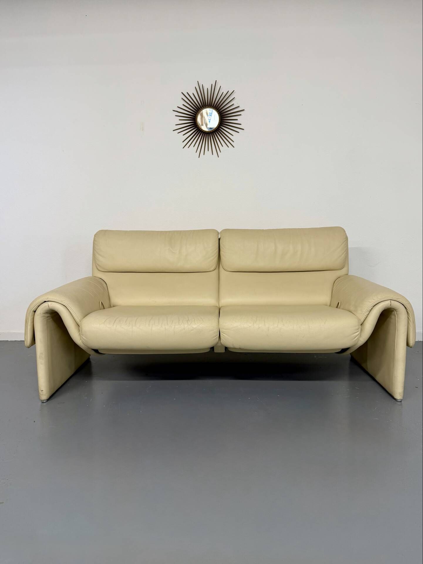 Two-seater designer sofa De Sede DS-2011 in cream leather with adjustable backrest.