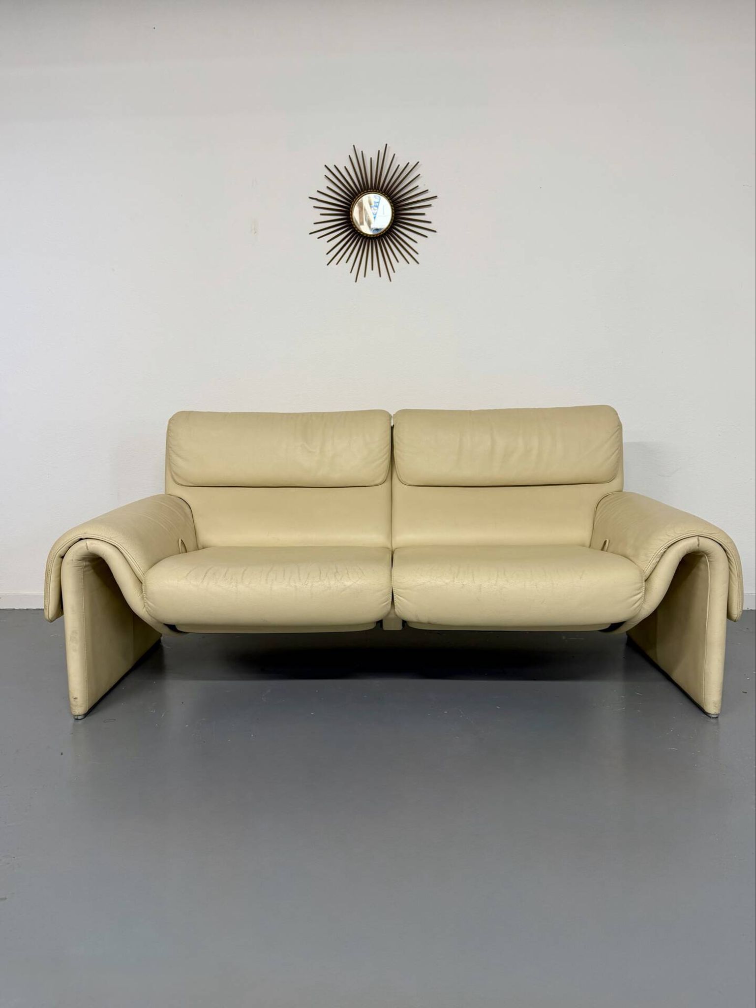 Two-seater designer sofa De Sede DS-2011 in cream leather with adjustable backrest.