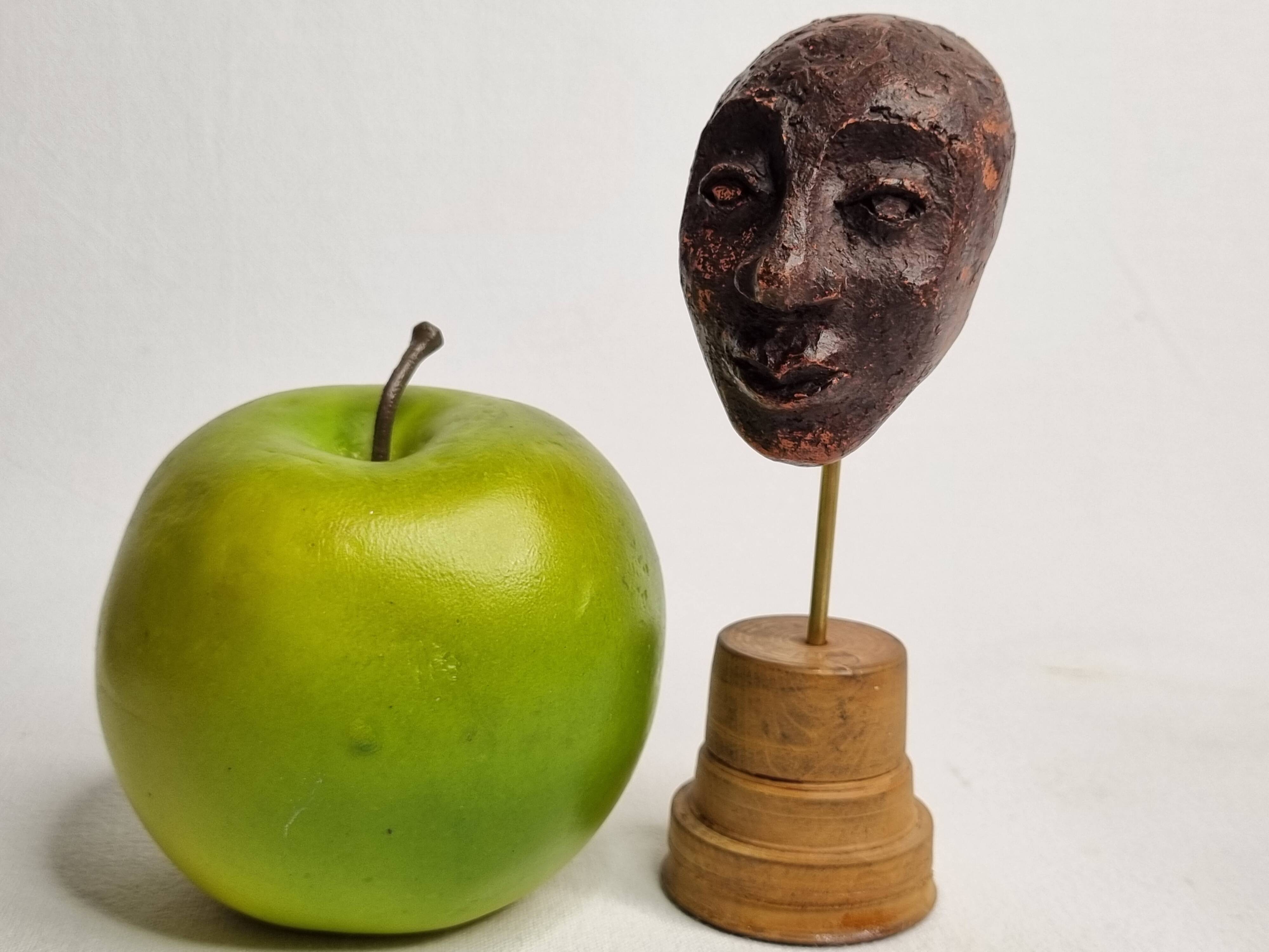 Expressive sculpted head in patinated terracotta on wooden base, 14 cm