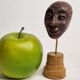 Expressive sculpted head in patinated terracotta on wooden base, 14 cm