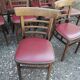 Set of 19 vintage wooden bistro chairs with red faux leather.