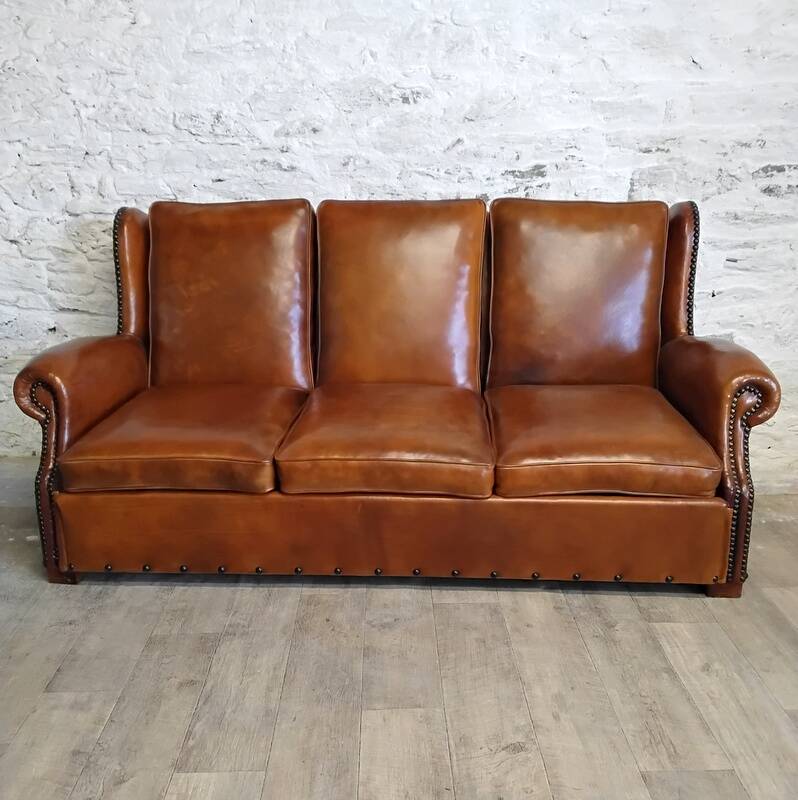 Living room with a sofa and wingback armchairs.