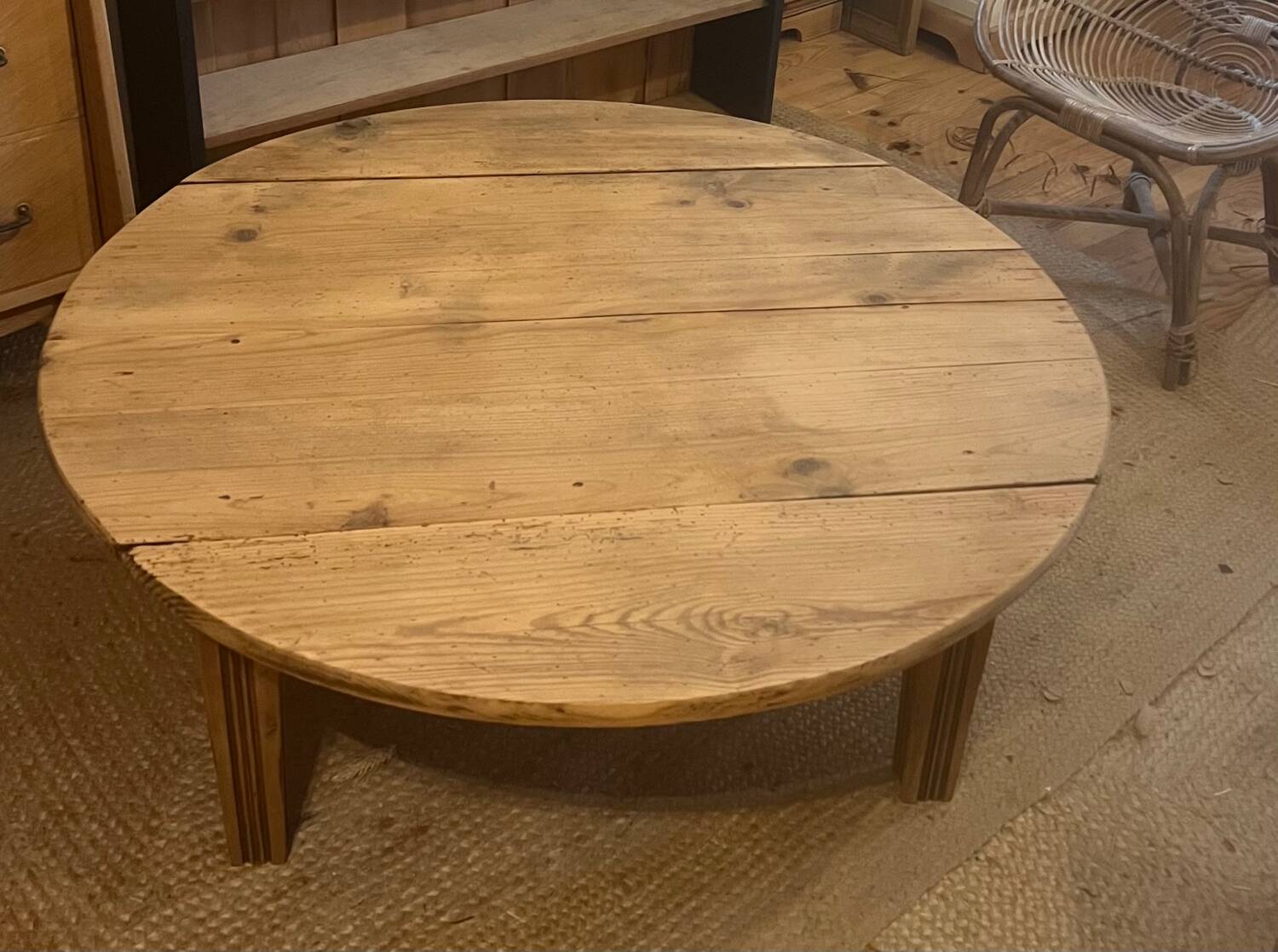 Large round antique coffee table made of raw solid wood.