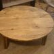 Large round antique coffee table made of raw solid wood.