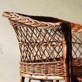 Woven rattan armchair with armrests.