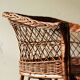 Woven rattan armchair with armrests.
