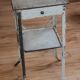 Painted metal side table, patinated white, with a drawer and two shelves