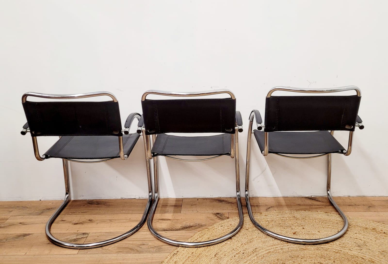 Three armchairs in black leather and steel tube