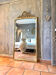 Antique mirror with a gilded pediment in the Louis XVI style.