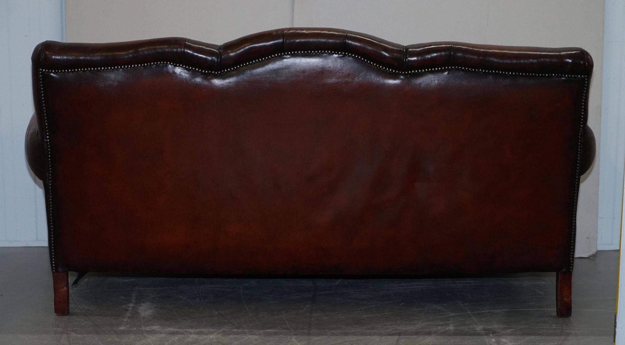 Restored Victorian sofa in leather with claw feet and feather cushions.