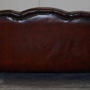 Restored Victorian sofa in leather with claw feet and feather cushions.