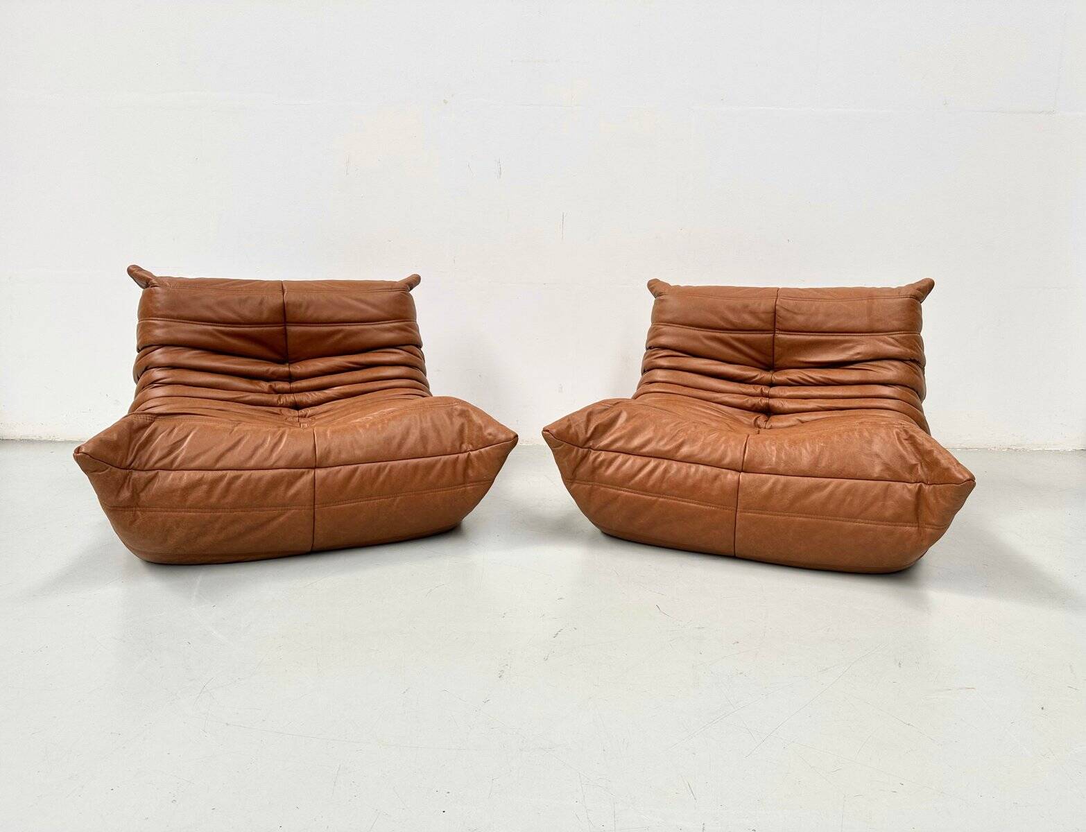 Togo lounge chairs in cognac cow leather attributed to Michel Ducaroy for Ligne Roset, set of 2