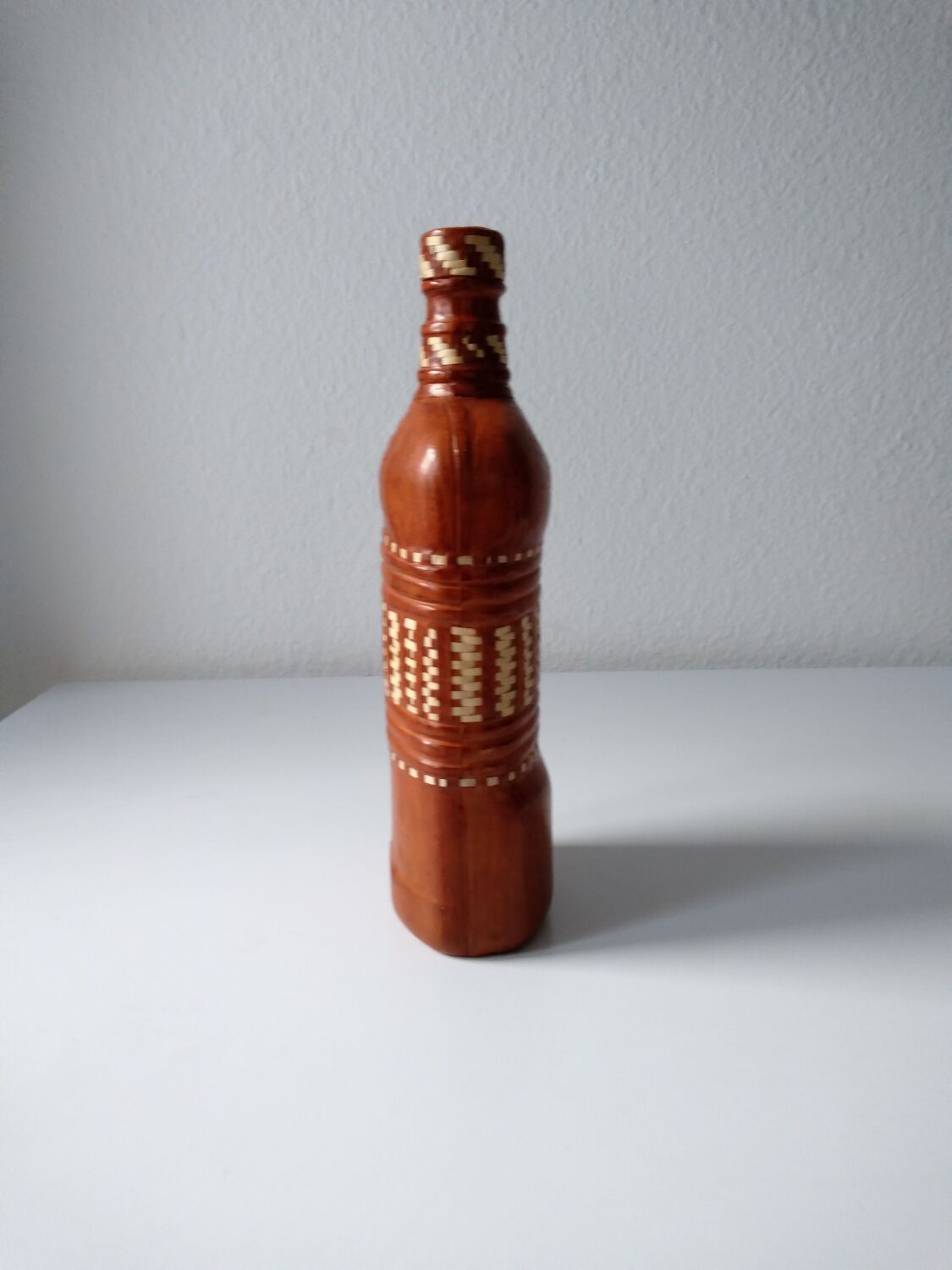 Vintage glass bottle covered with light brown leather and wicker